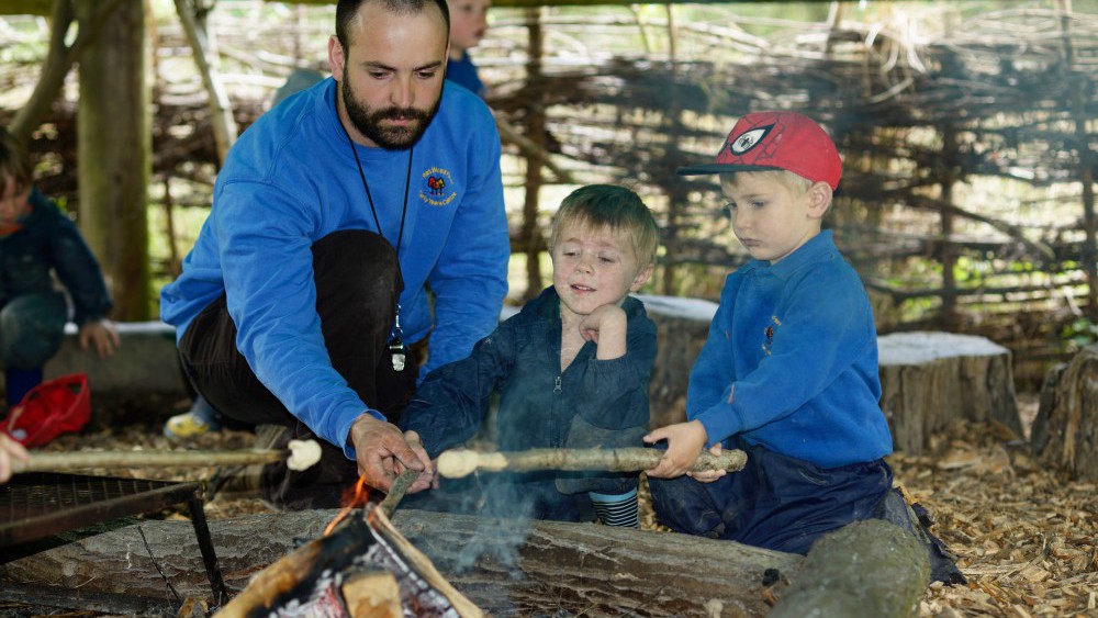 pre-school children toasting marchmallows on forest school
