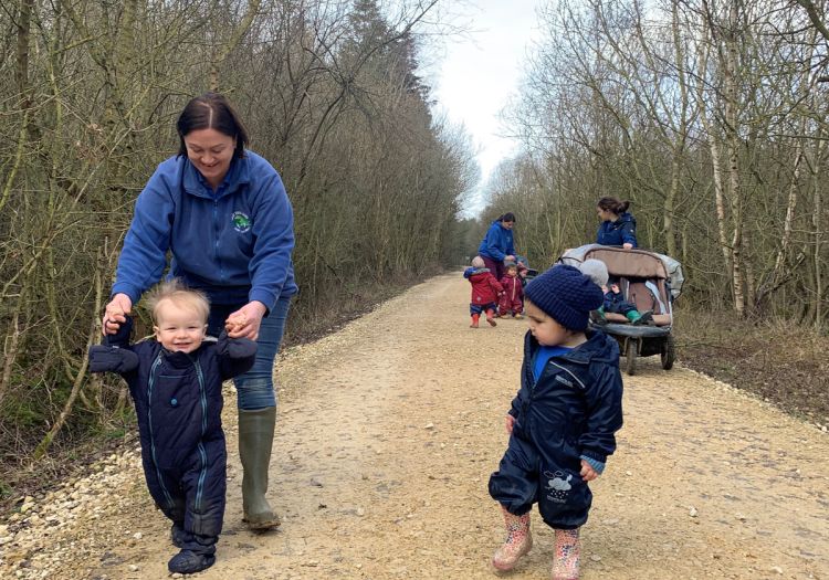 babies learning to walk in woods