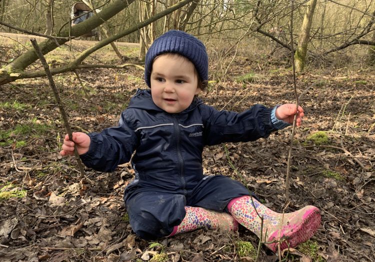 Baby playing with stick in nature