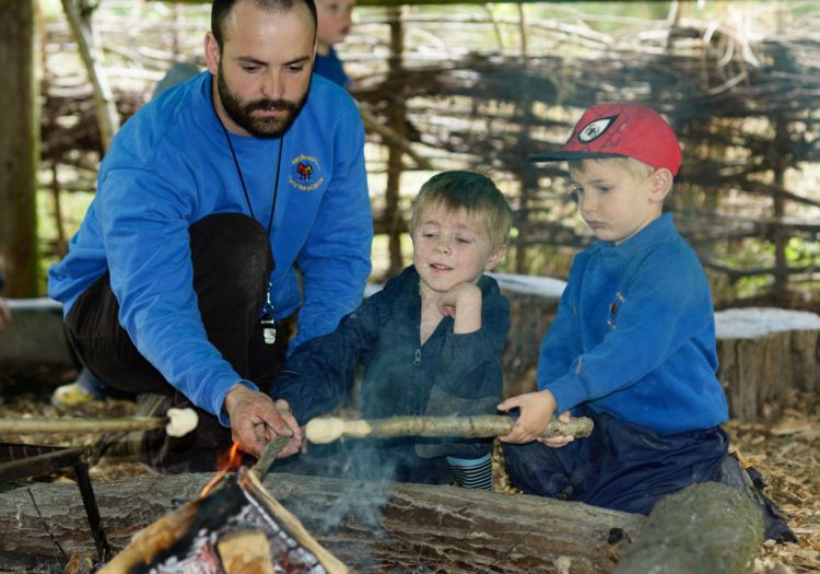 pre-school children toasting marchmallows on forest school
