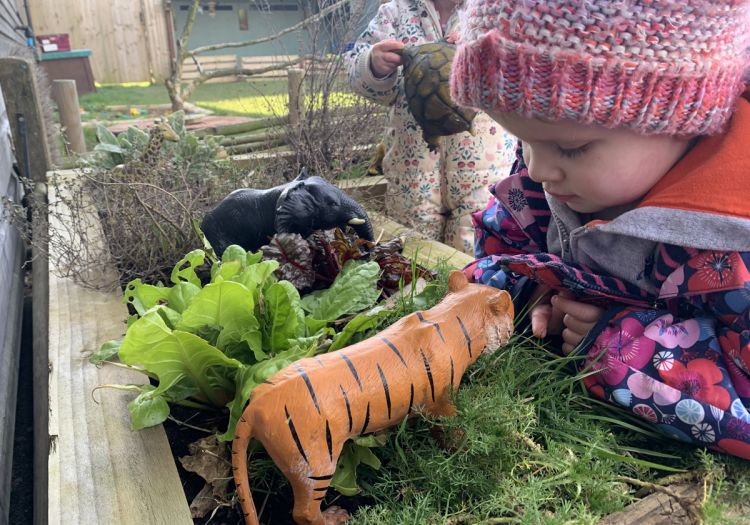 Baby playing small world play with herbs